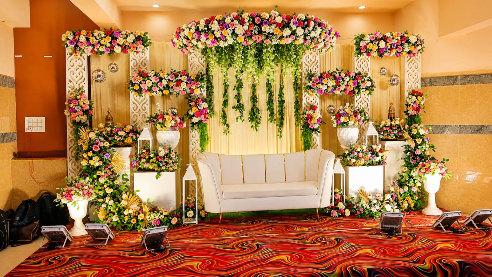 Ivory & gold reception stage with hanging vines, floral canopy and cream throne