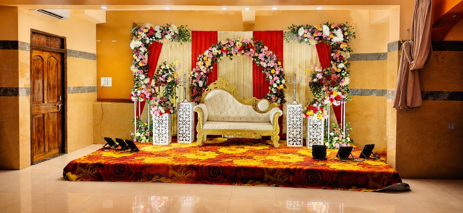 Regal ivory & gold wedding throne with pastel floral arch backdrop
