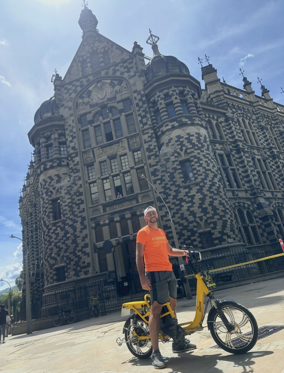 Visitante con bicicleta eléctrica frente al Palacio de la Cultura Rafael Uribe Uribe, Medellín