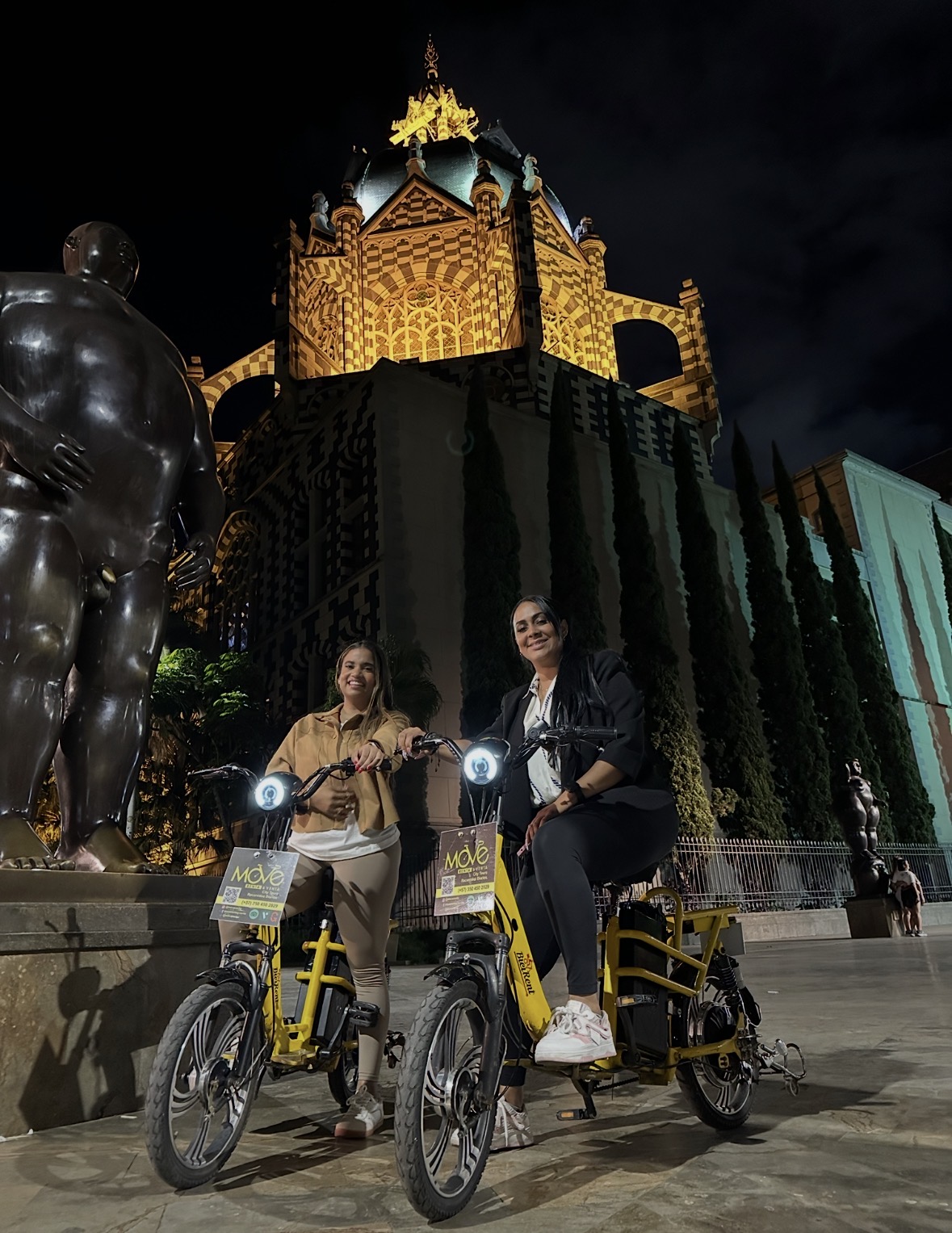Pareja en tour nocturno en bicicleta eléctrica por el centro de Medellín