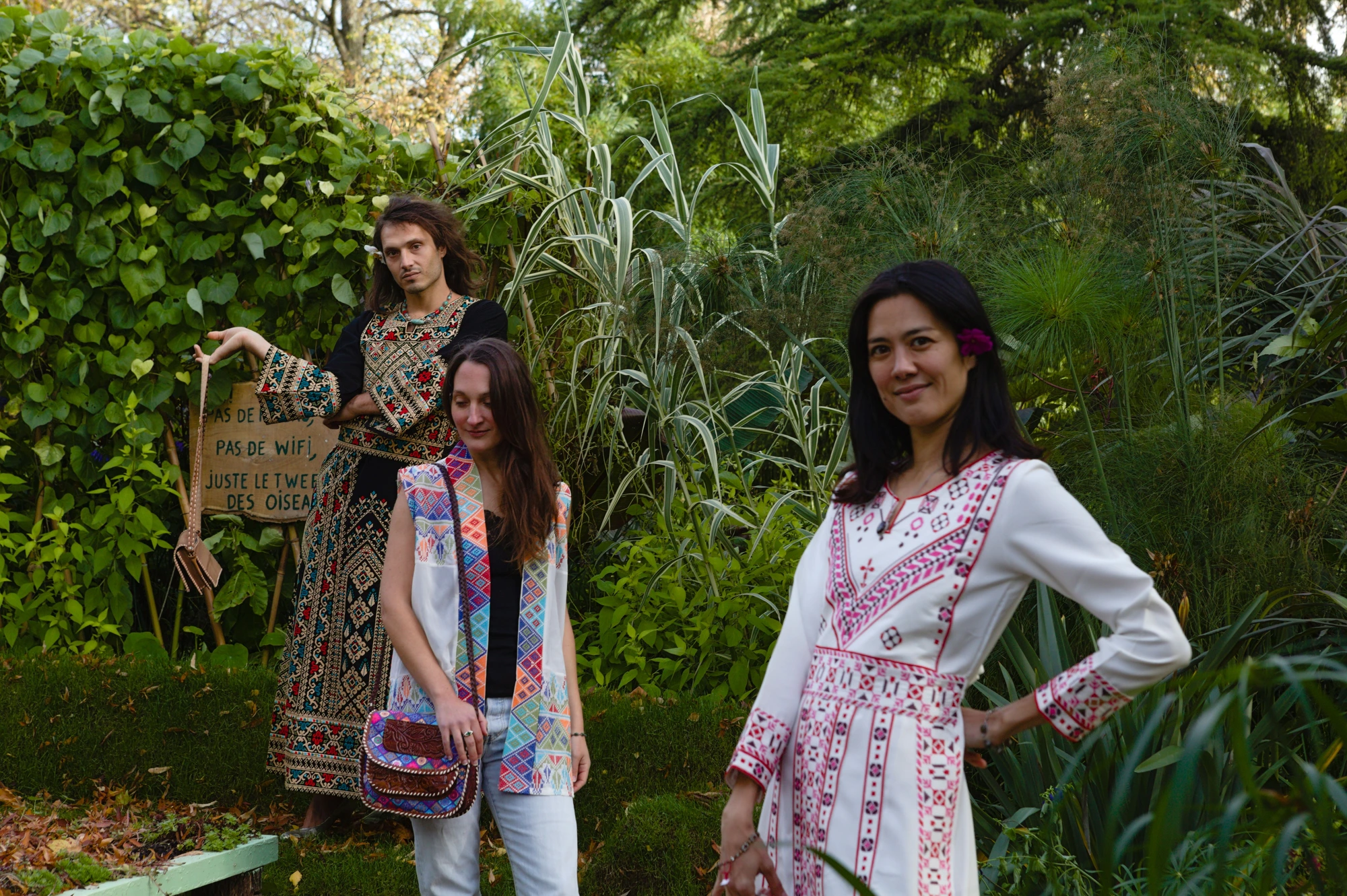 Groupe portant des créations Levami dans un jardin végétal.
