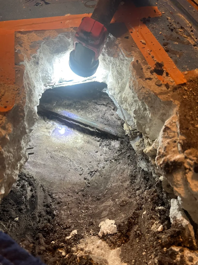 Slab leak repair with power tool cutting through concrete