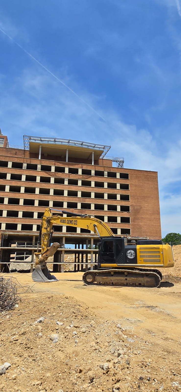 Robo Demo Co. excavator demolishing a multi-story concrete structure