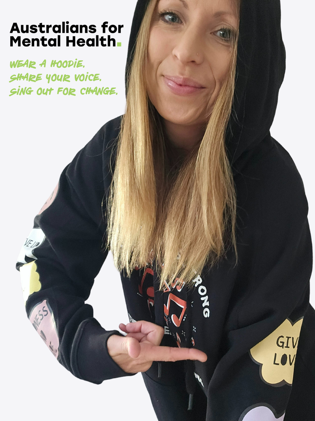 Louise in the Australians for Mental Health hoodie pointing at the Sing Out For Change sleeve