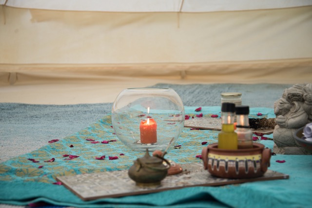 Candle, oils and small offerings inside the tent
