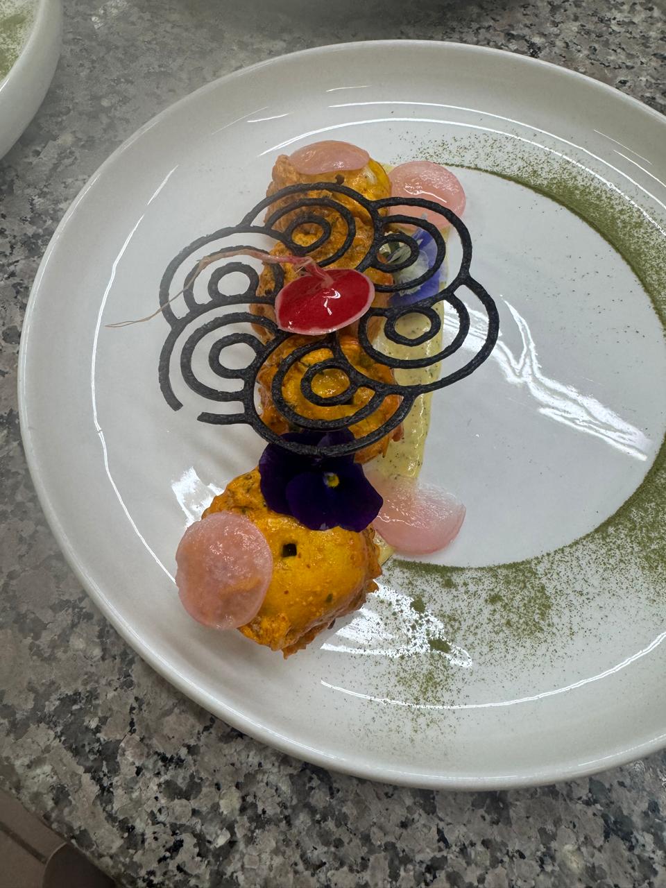 Saffron tikka with black calligraphy tuile and pickled radish
