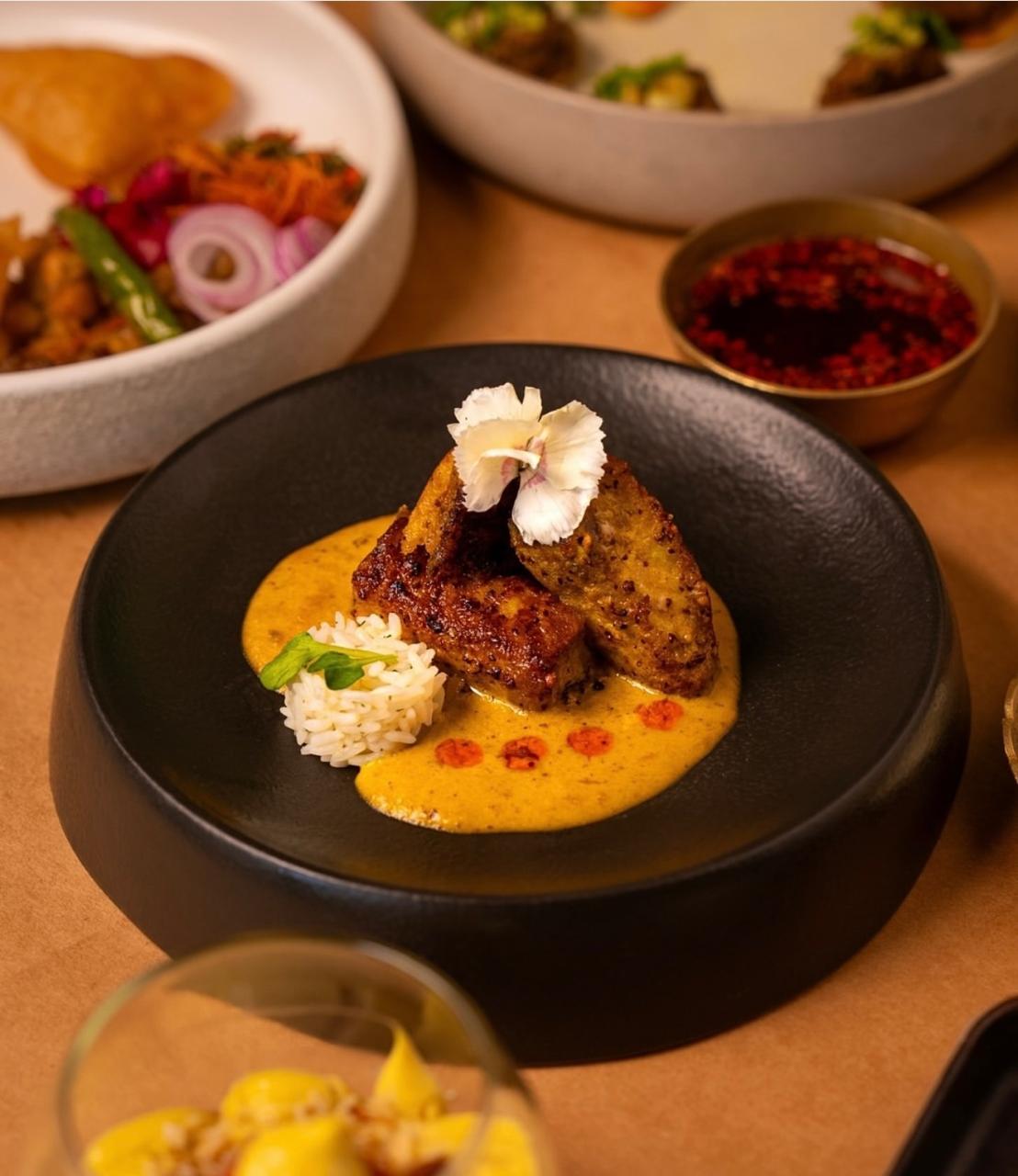 Mustard fish steak with rice on black plate