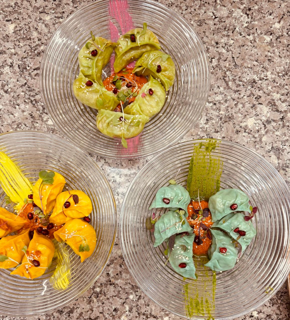 Trio of colorful momos with red chutney