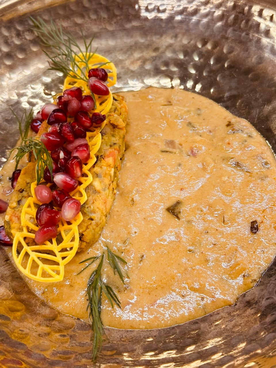 Kebab patty with pomegranate on brass platter