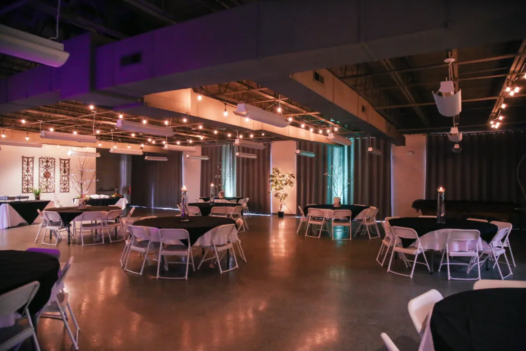 The McKissick Center dining hall set for an event with round tables and string lights