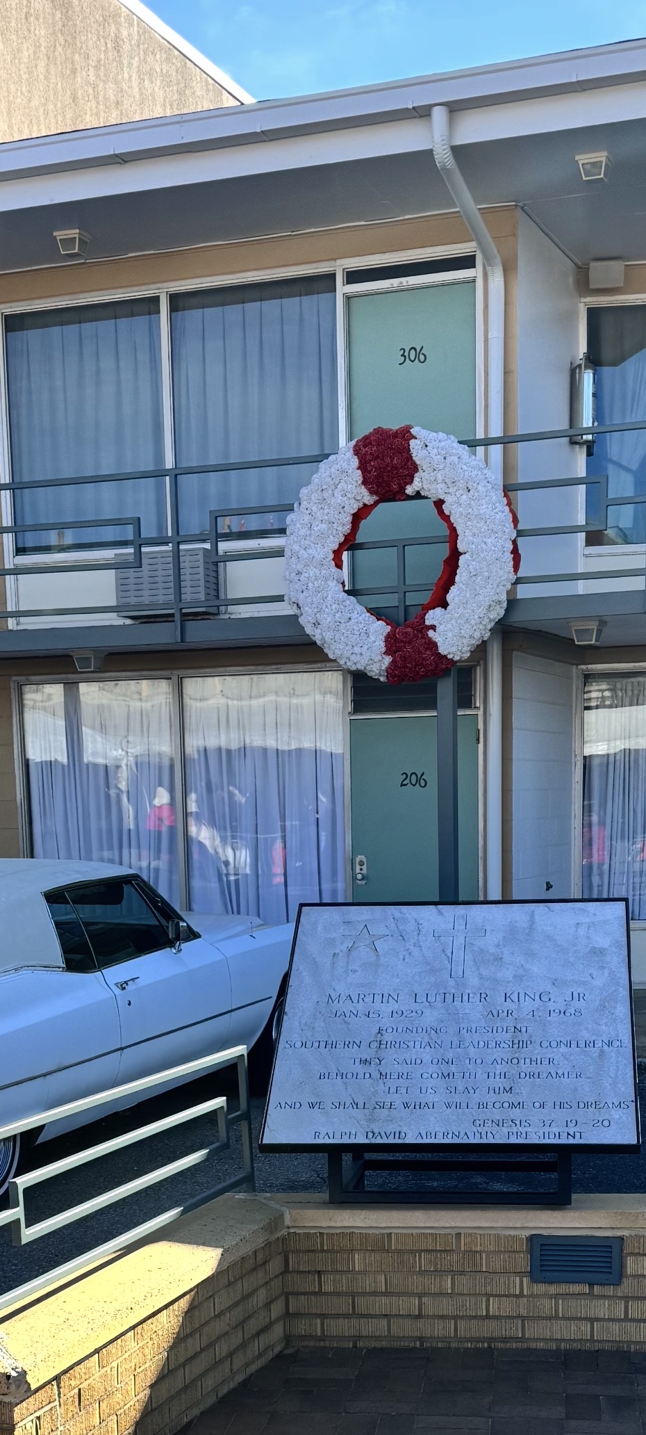 The Lorraine Motel balcony outside Room 306 with the memorial wreath and period cars, now the National Civil Rights Museum