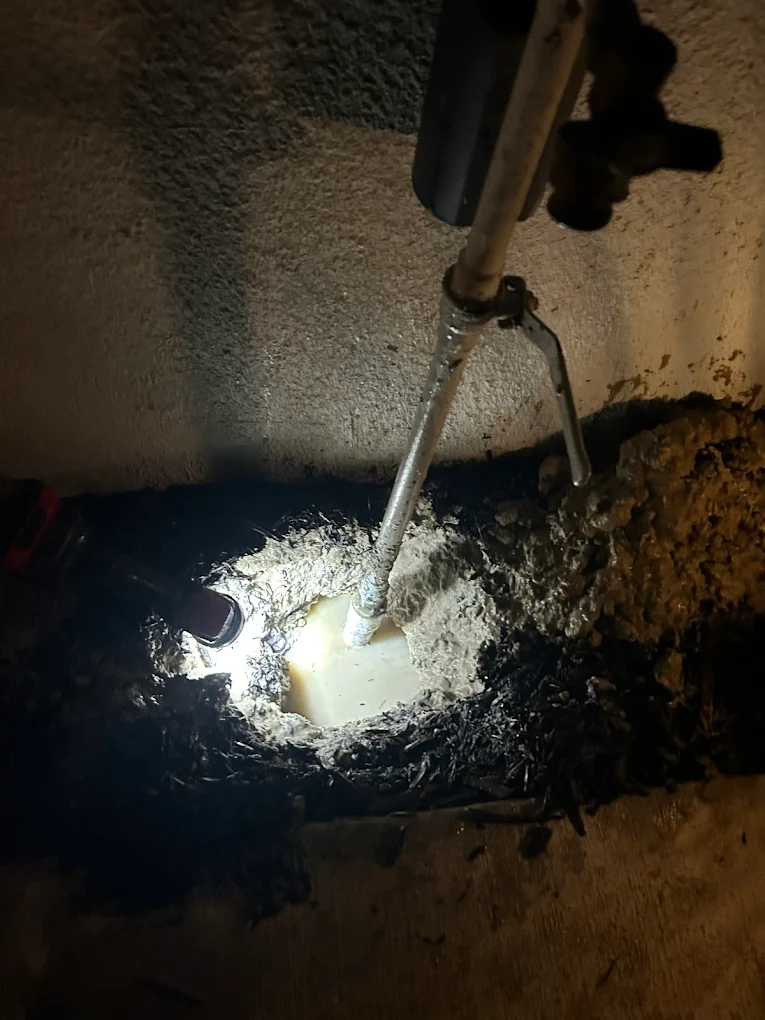 Underground slab leak repair showing exposed pipe and water damage