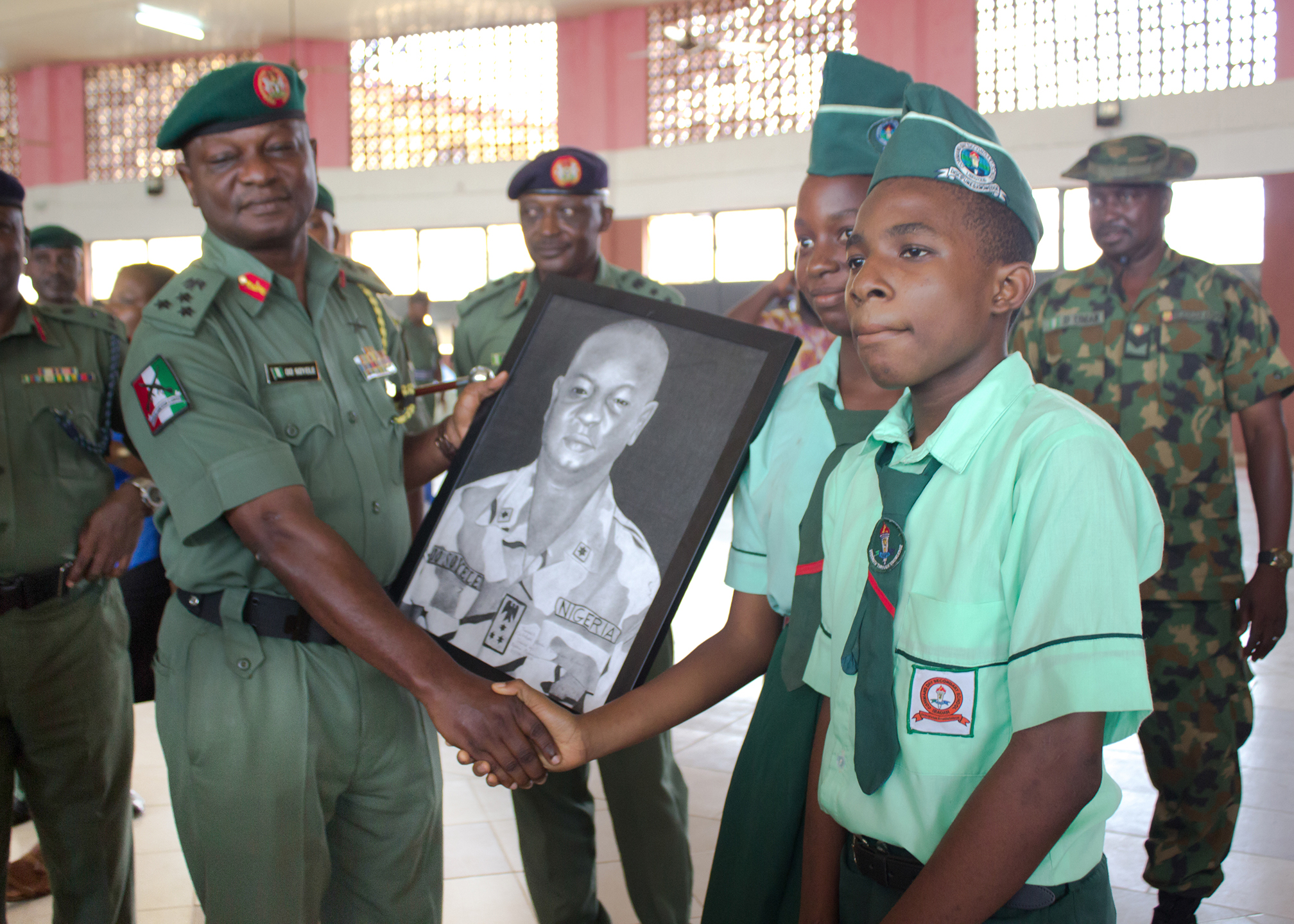 Student presenting portrait to official