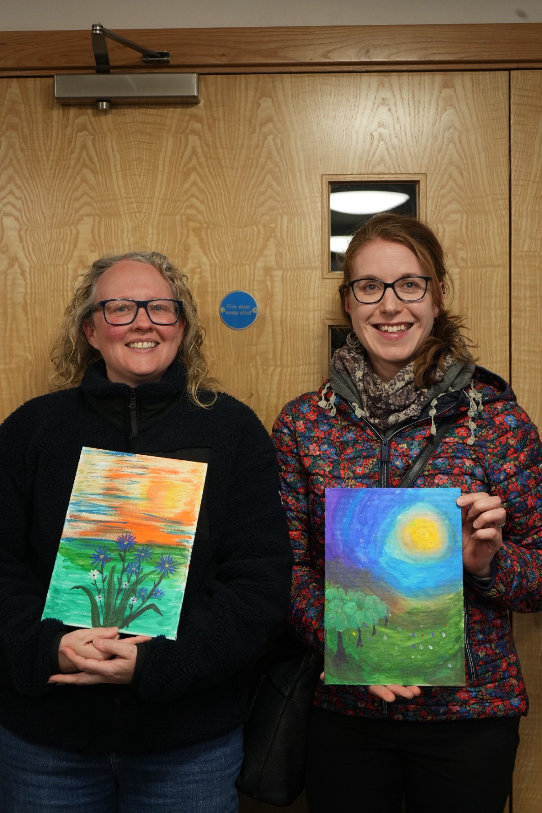 Two participants with finished paintings