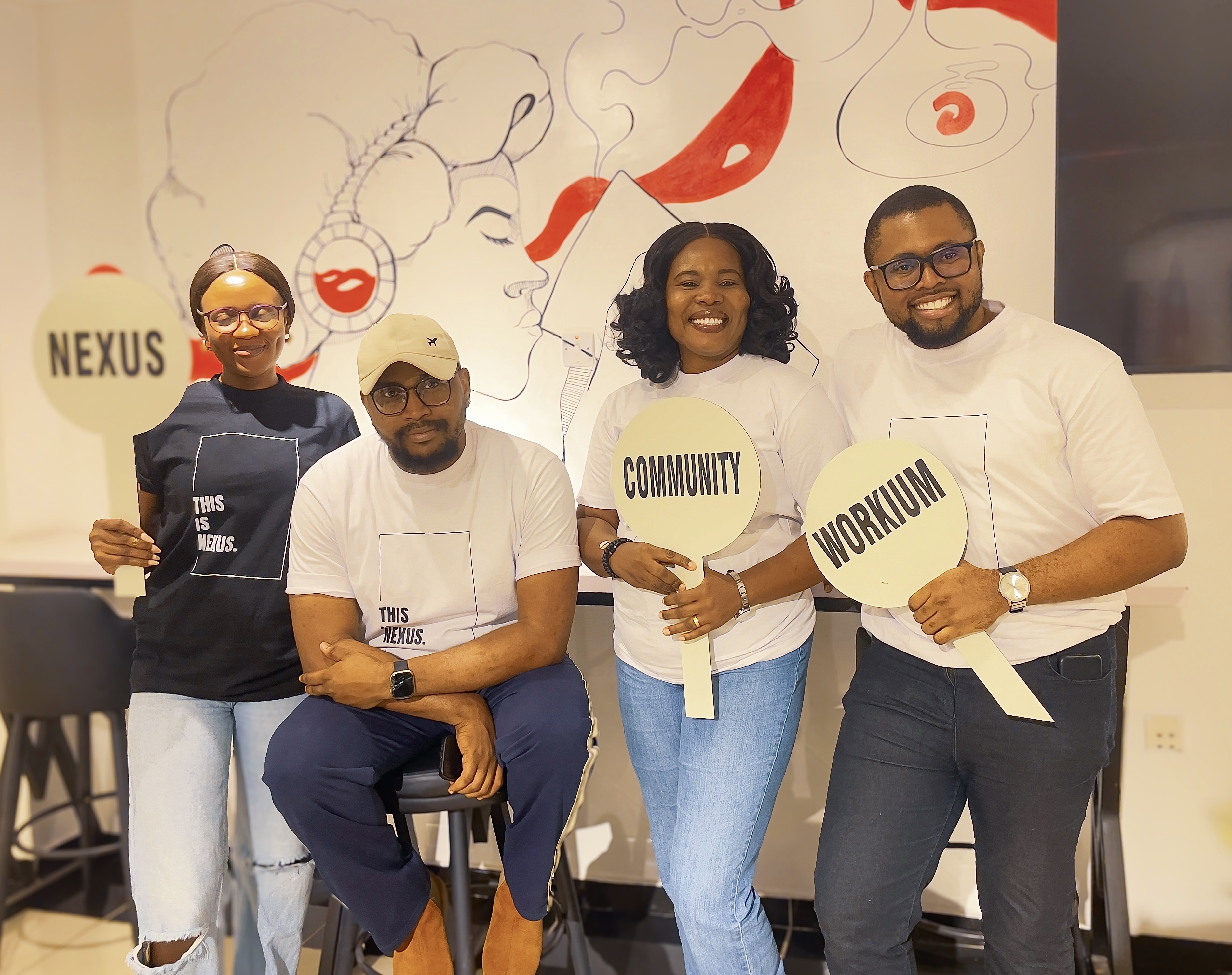 Four members holding Workium · Nexus signs in Abuja