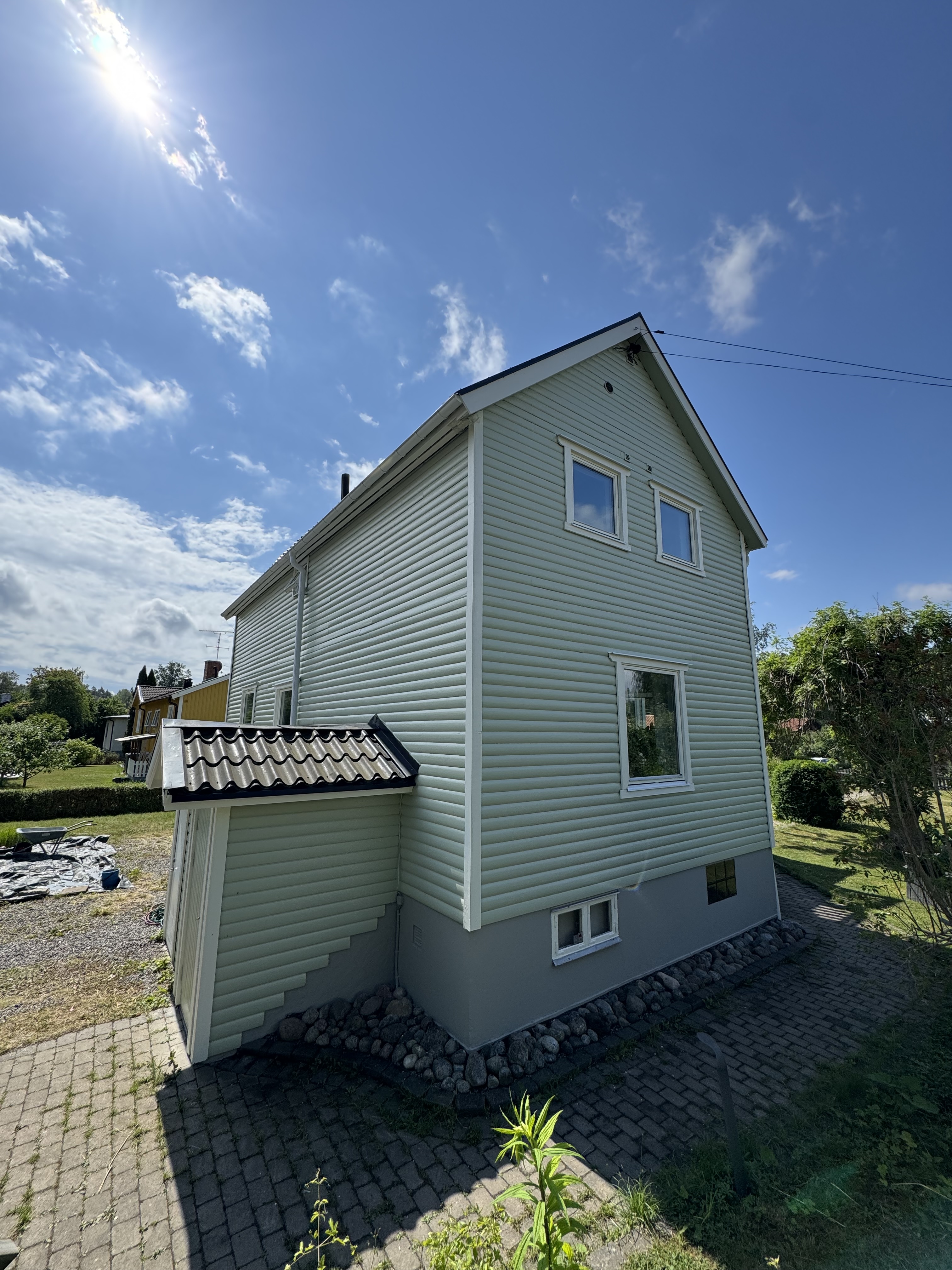Nymålat ljusgrönt trähus efter fasadmålning