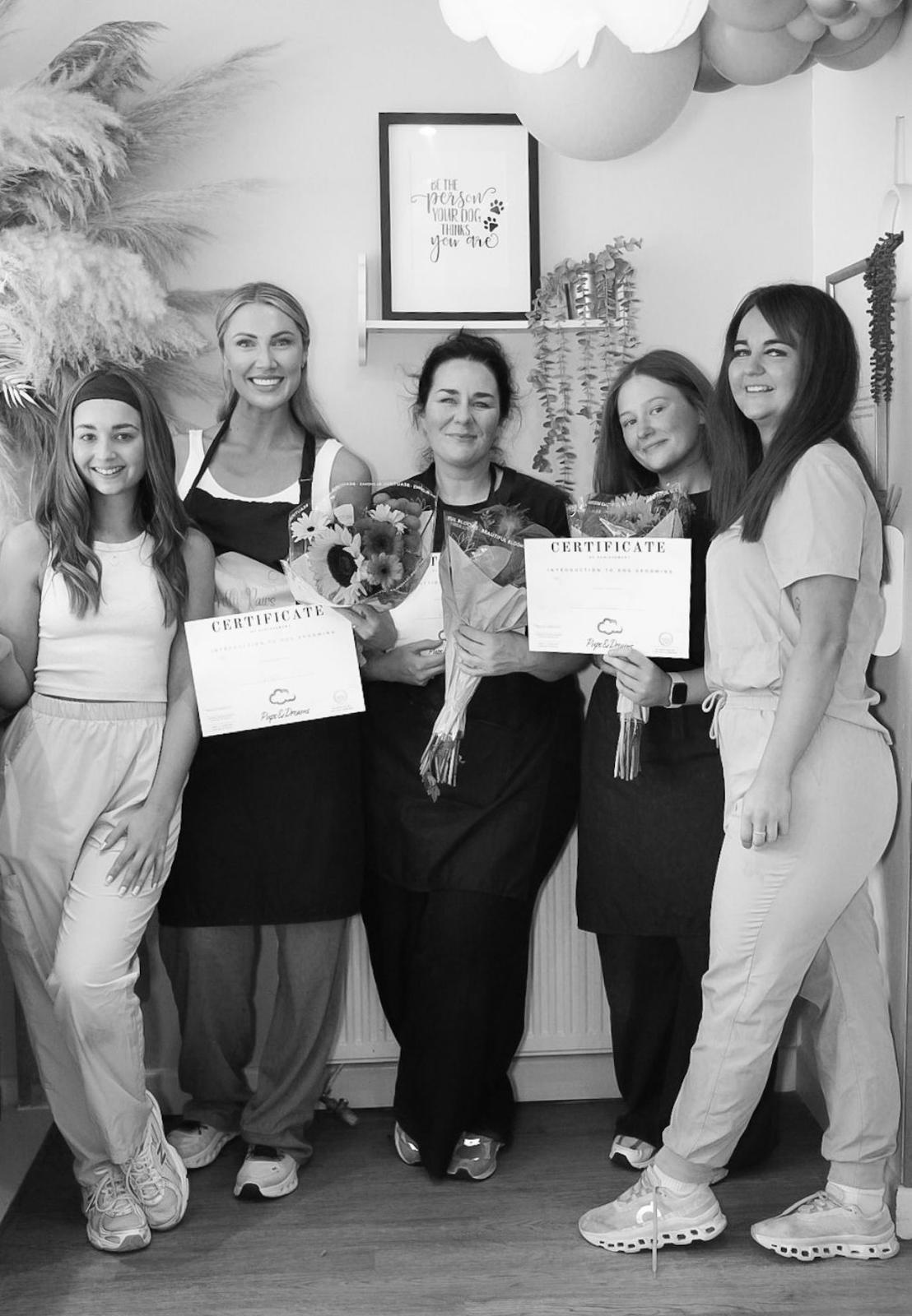 Pups & Dreams Academy graduates holding CPD certificates and flowers
