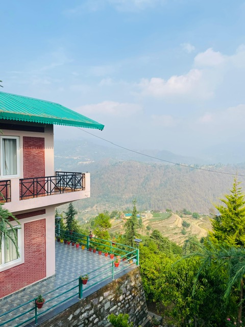 Banpravas — the upper terrace lined with flower pots, the Kumaon valley falling away behind