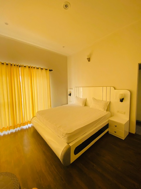 Banpravas — a contemporary suite, soft yellow light through floor-length curtains