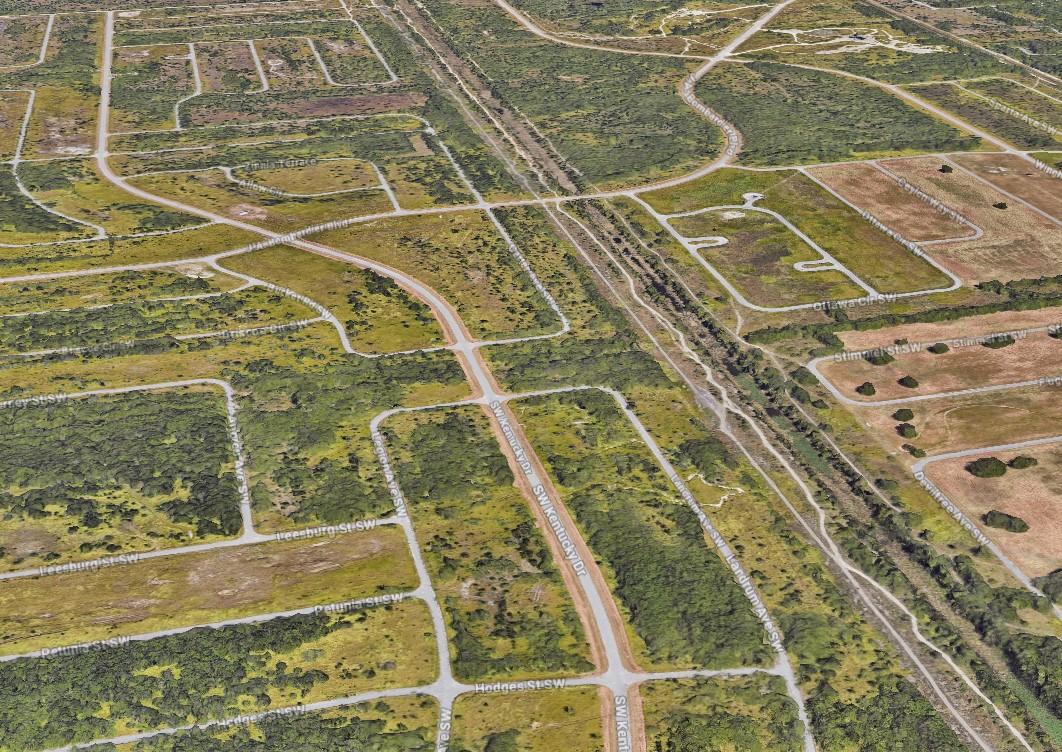 Aerial view of The Compound at Port Malabar in Palm Bay, FL — Units 51, 52, and 53 — showing the scale of the undeveloped grid stretching to the horizon