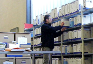 Manutentionnaire ArchivExpress organisant des cartons d'archives sur rayonnages