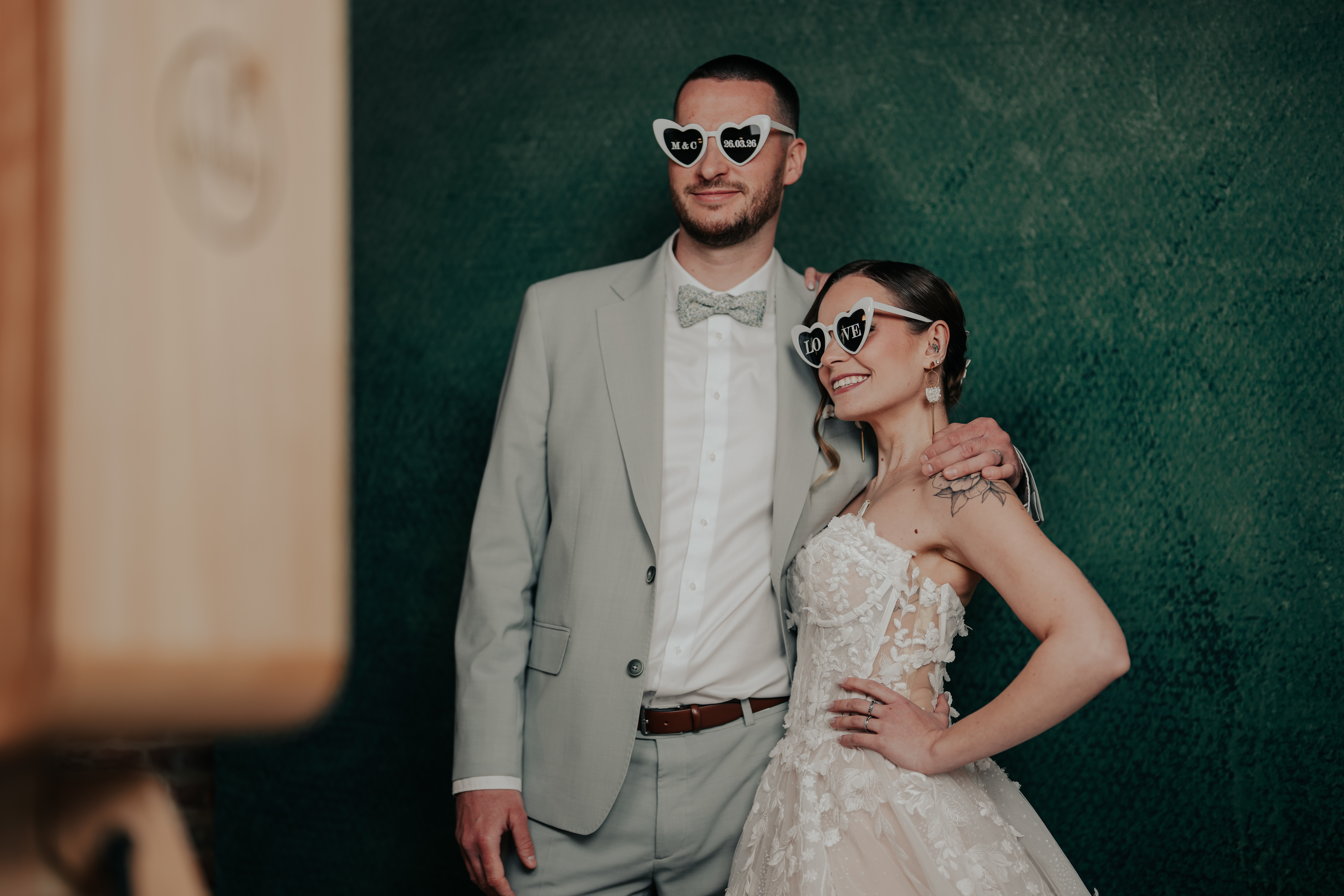Couple de maries heureux devant leur photobooth vintage le jour de leur mariage