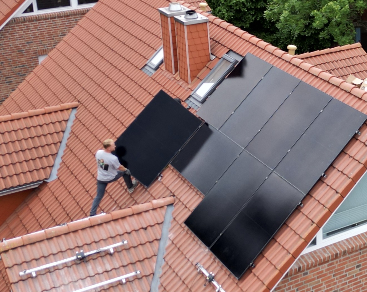 Photovoltaik-Montage Bremen – Dachdecker bei PV-Installation, Drohnenaufnahme