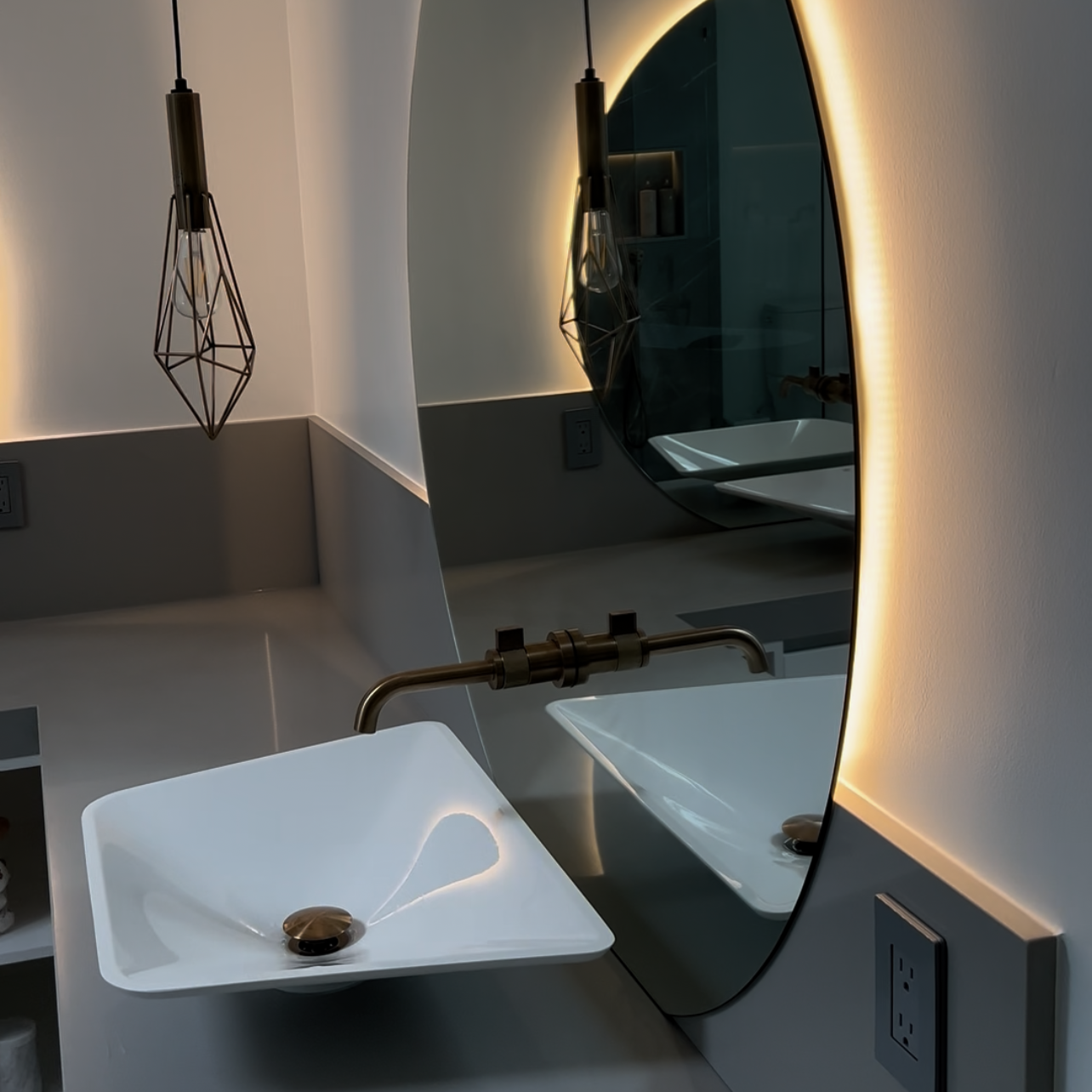 Designer Vancouver bathroom renovation with floating vanity, brushed brass faucet and backlit oval mirror