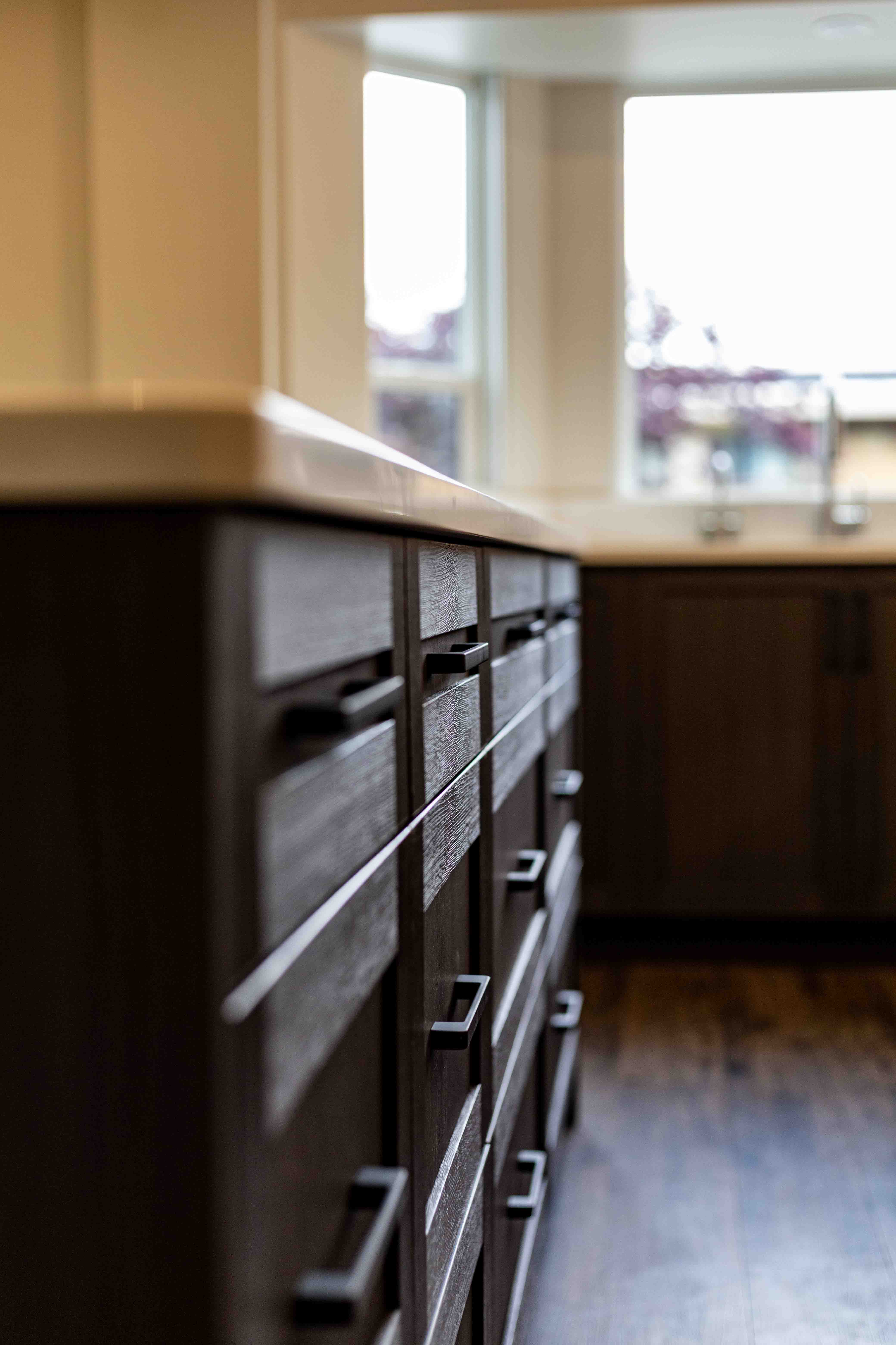 Detail of walnut cabinetry with matte black hardware — Vancouver designer kitchen renovation