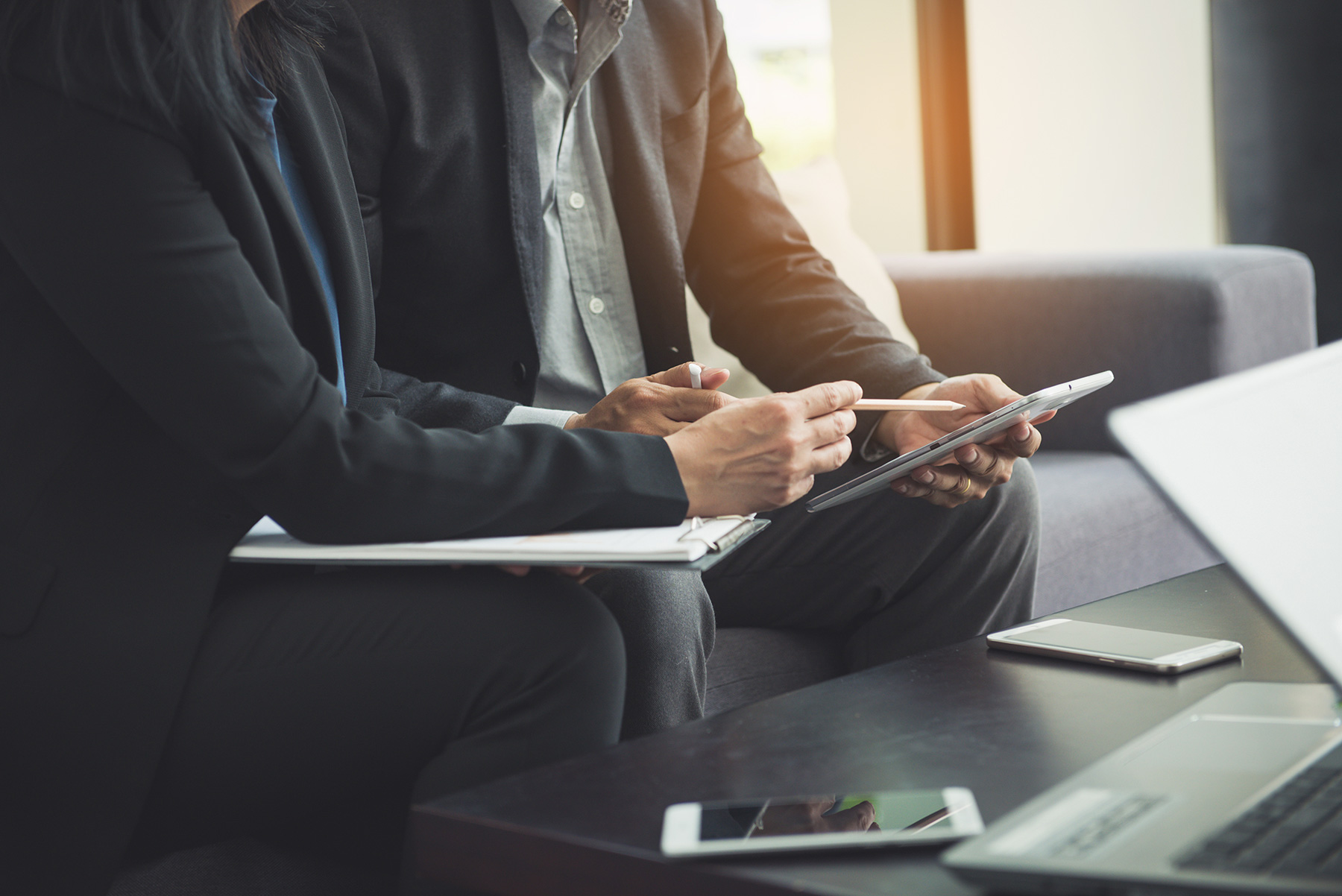 Asian business professionals reviewing investment portfolio on tablet