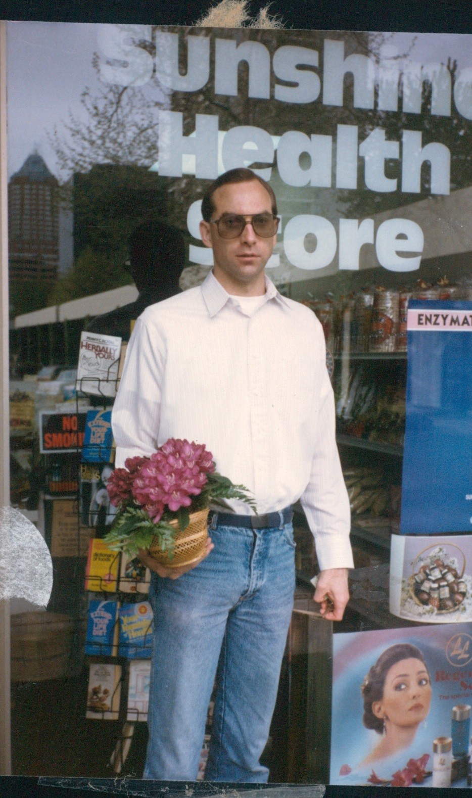 Randy outside Sunshine Health Store, holding a basket of African violets