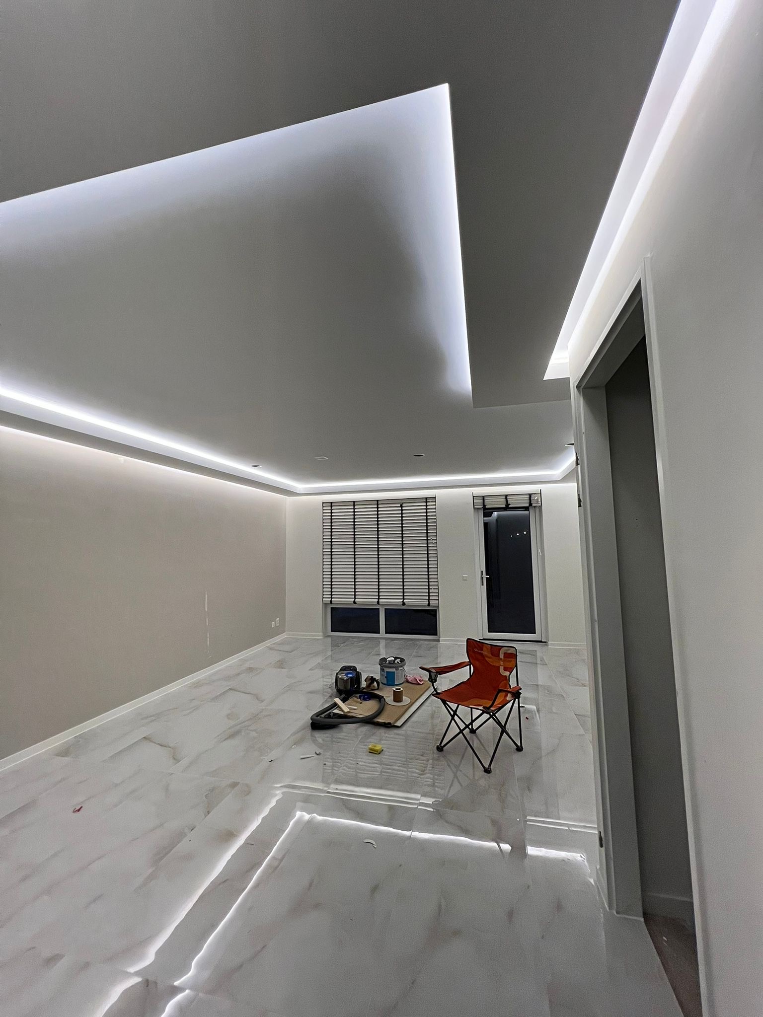 Afgewerkte ruimte met LED plafond en marmeren vloer