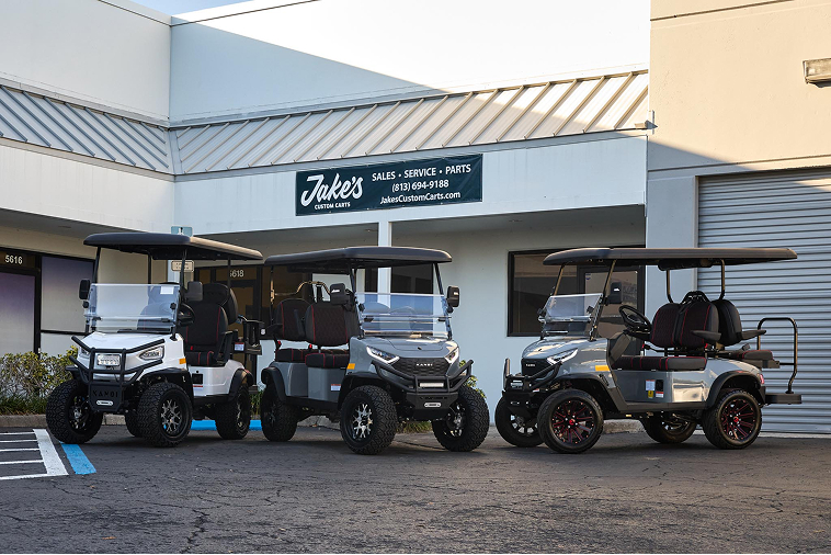 The current Jake's Custom Carts shop at 5618 56th Commerce Park Blvd in Tampa — storefront banner reading Sales · Service · Parts, with three lifted carts staged out front