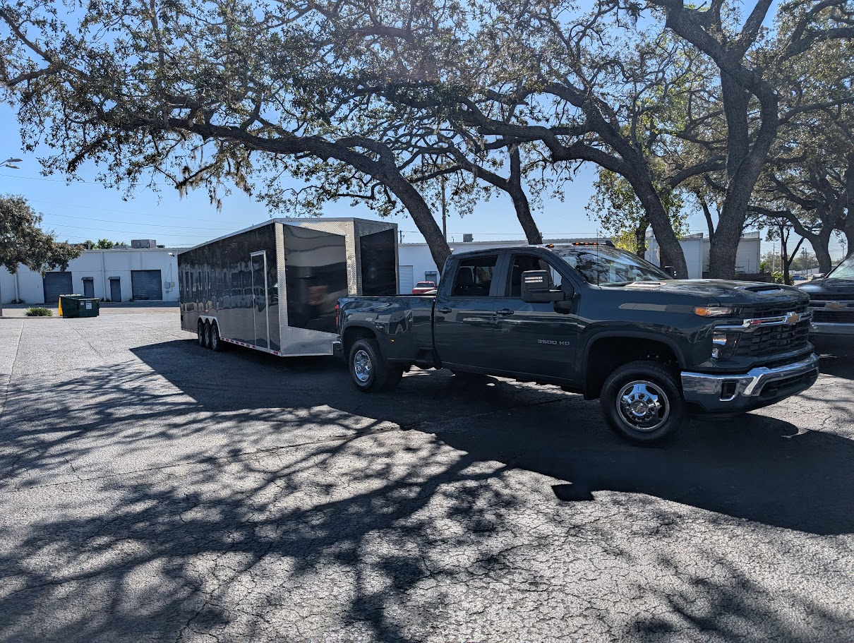 Jake's Custom Carts newest delivery rig — a Chevy 3500 HD dually truck pulling a 36-foot enclosed trailer outside the Tampa shop