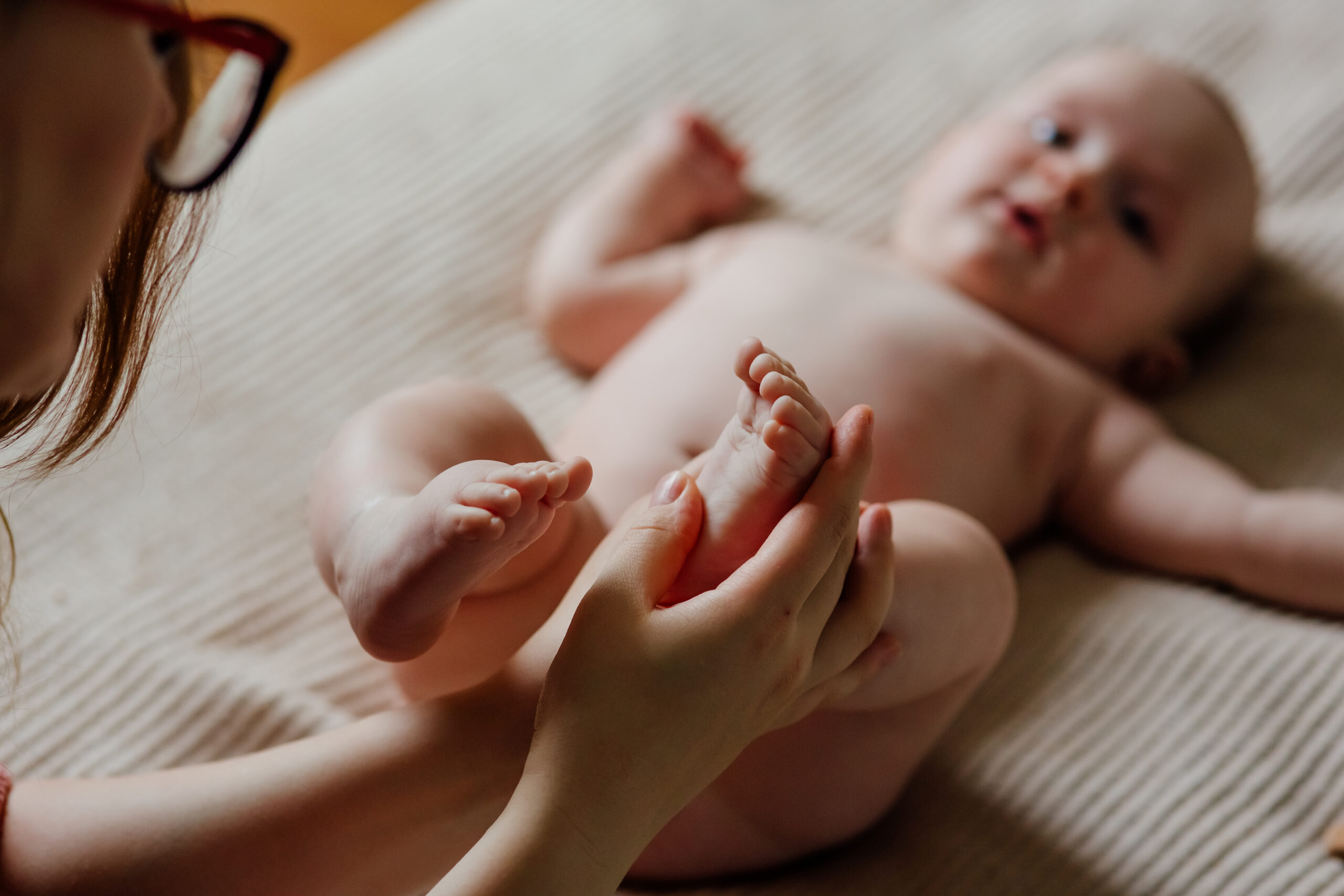 Massage bien-être bébé — pieds de nourrisson tenus tendrement
