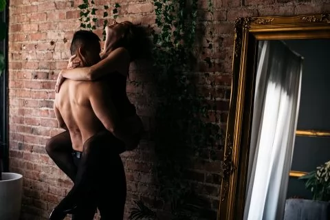 Intimate couples against brick wall