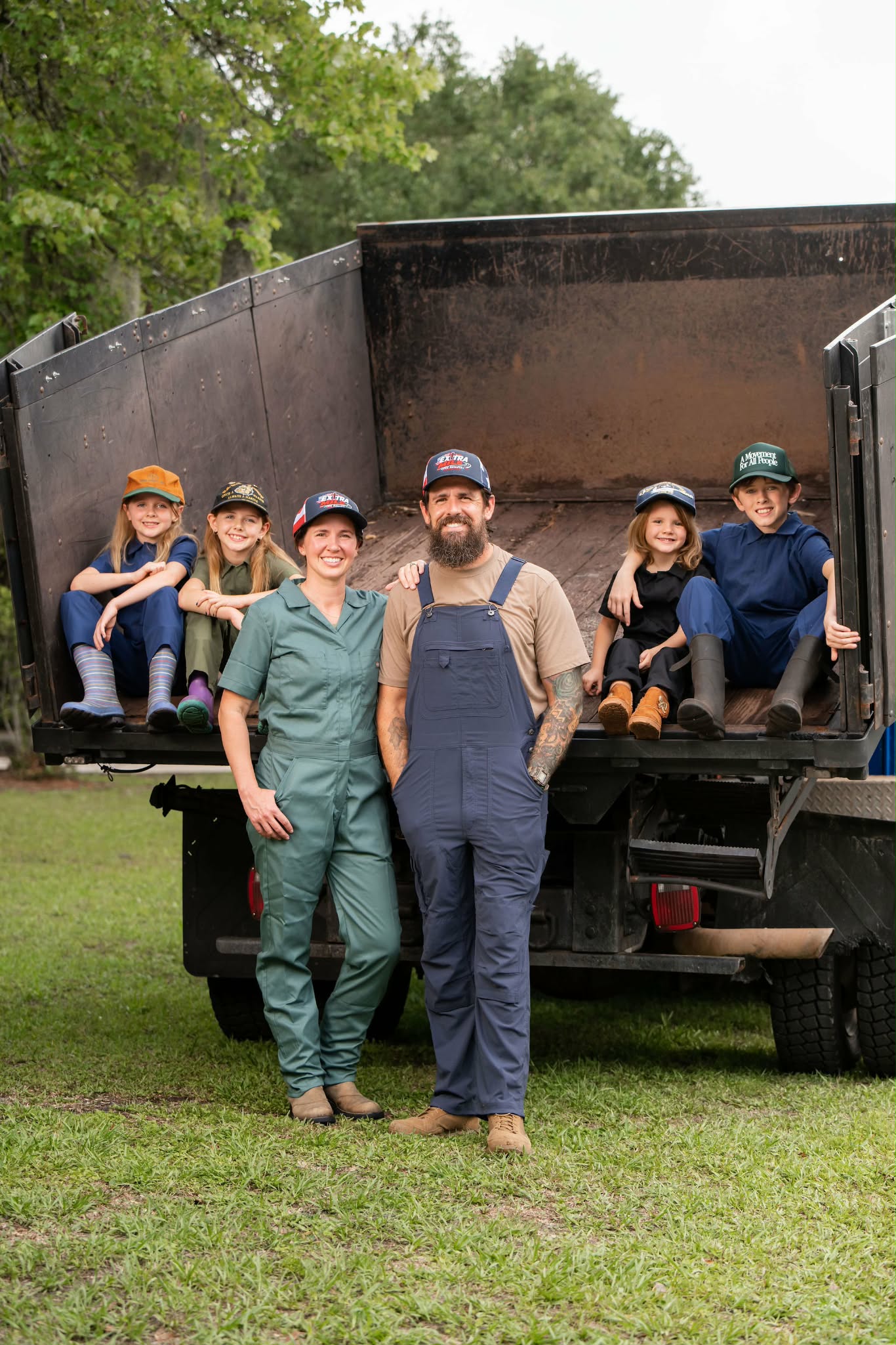 The Chandler family — Jesse, Tracy, and their 4 kids — by their Extra Mile Junk Removal truck