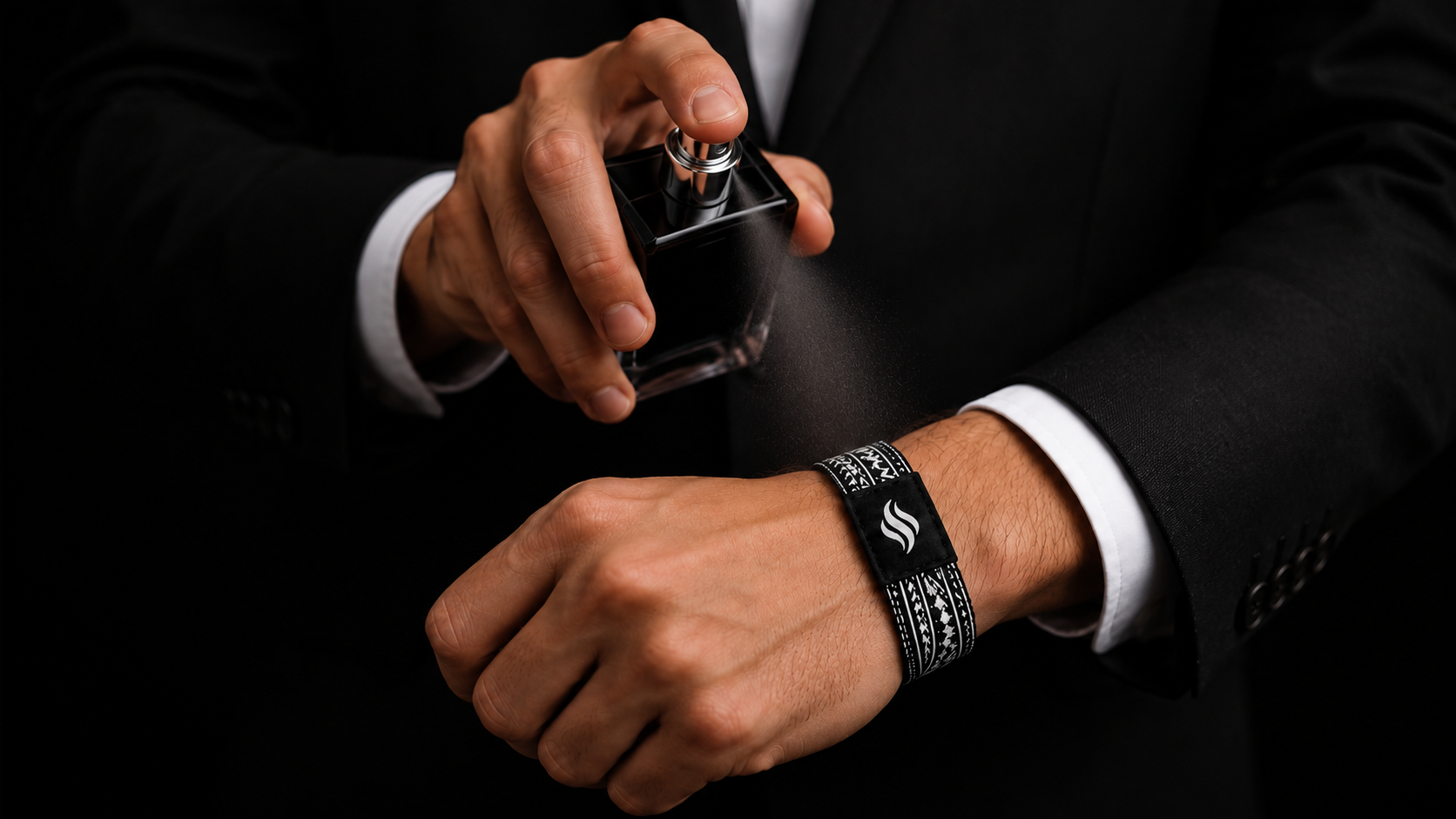 Woman in black dress spraying perfume onto her StayScent fragrance diffuser bracelet
