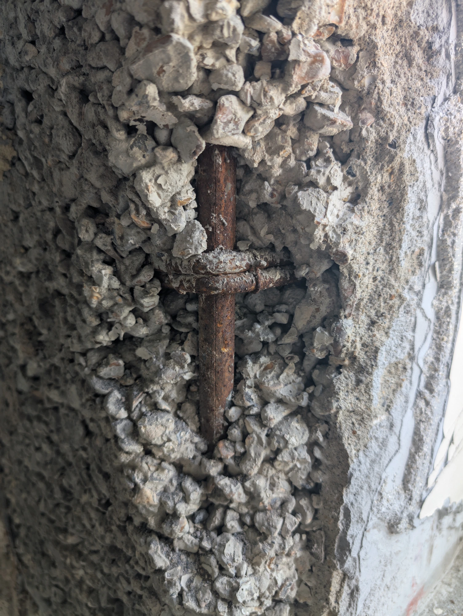 Corroded reinforcement inside broken-out concrete