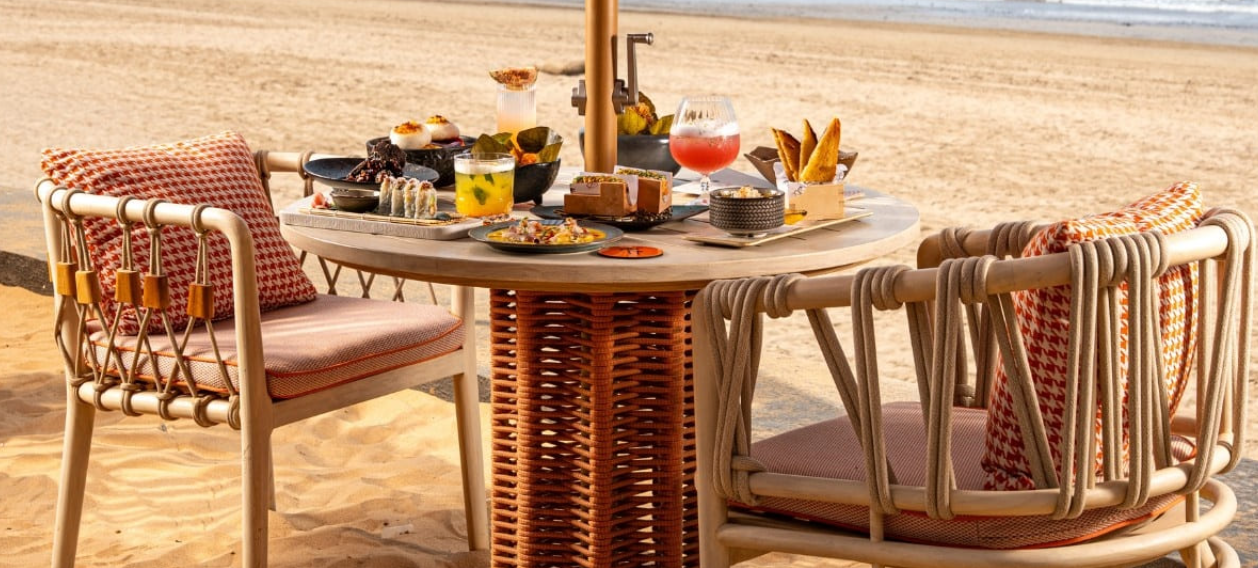 A curated table set on the sand at sunset