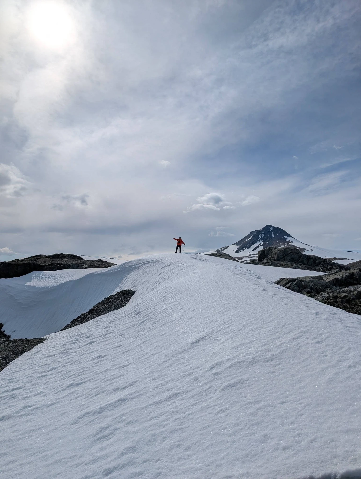 Leah on a snowy mountaintop pointing forward