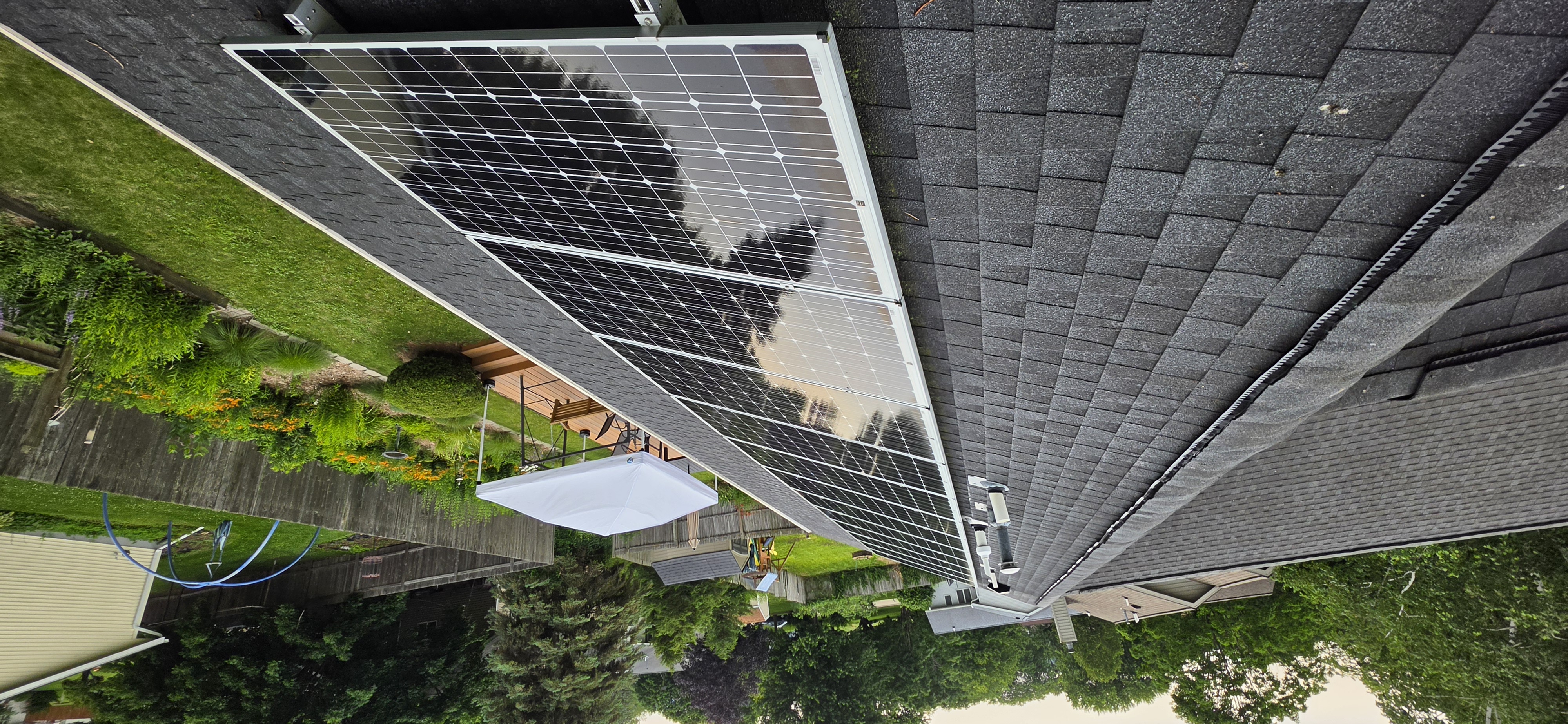Same solar array immediately after a Solar Alchemist clean — cumulus clouds visibly reflected on the glass