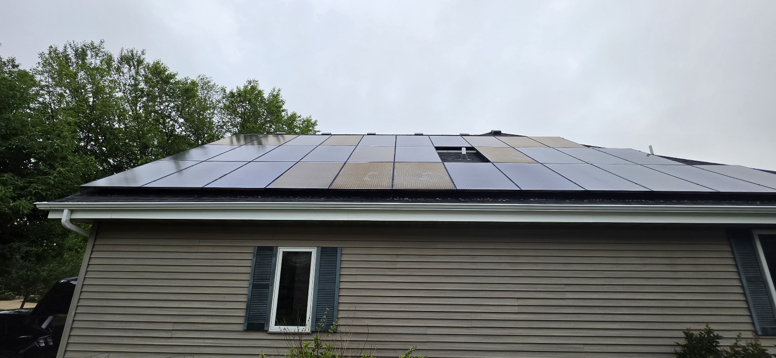 Same solar panel array AFTER cleaning — surface dust removed, revealing that several center panels have deep amber and tan EVA yellowing that was hidden by the dust layer