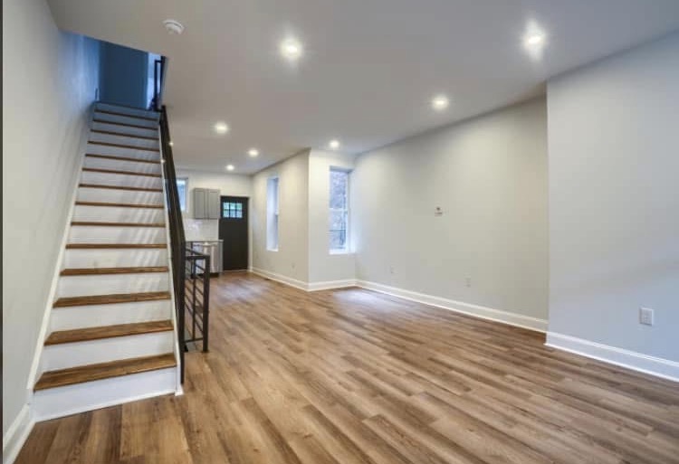 A finished Dorsey Taylor Homes interior — wood floors, fresh paint, refinished staircase, modern lighting
