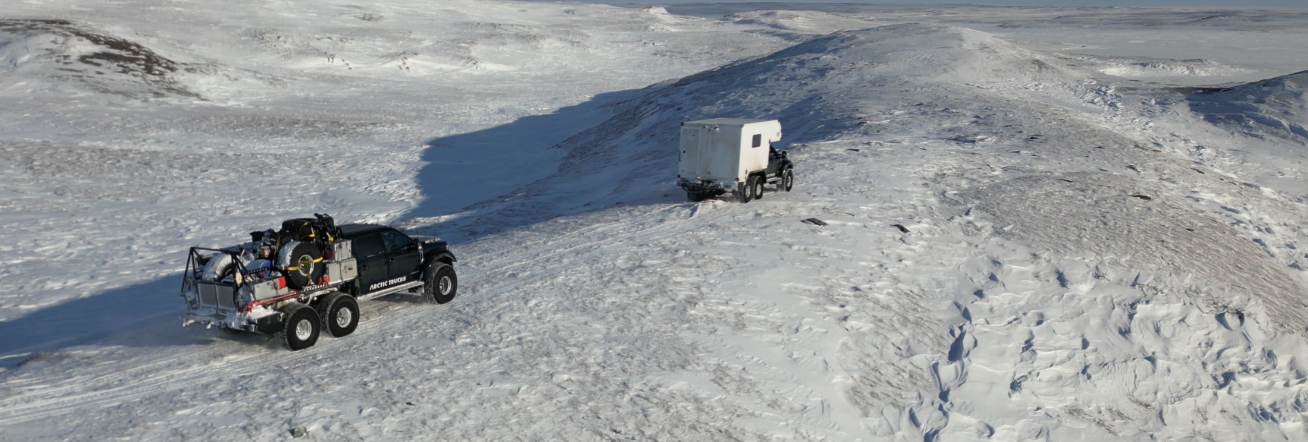 Arctic Trucks AT44 convoy with Total Composites habitat on Arctic ice ridge