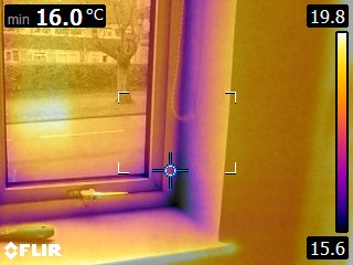 Thermal imaging of the window jamb and sill junction showing a localised cold zone at the corner detail. The reduced surface temperature indicates concentrated heat loss at the window perimeter and highlights a potential thermal weakness within the building envelope.