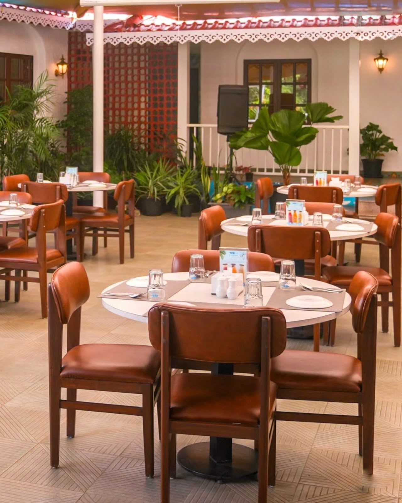 Open-air dining — terracotta upholstery & tropical planters