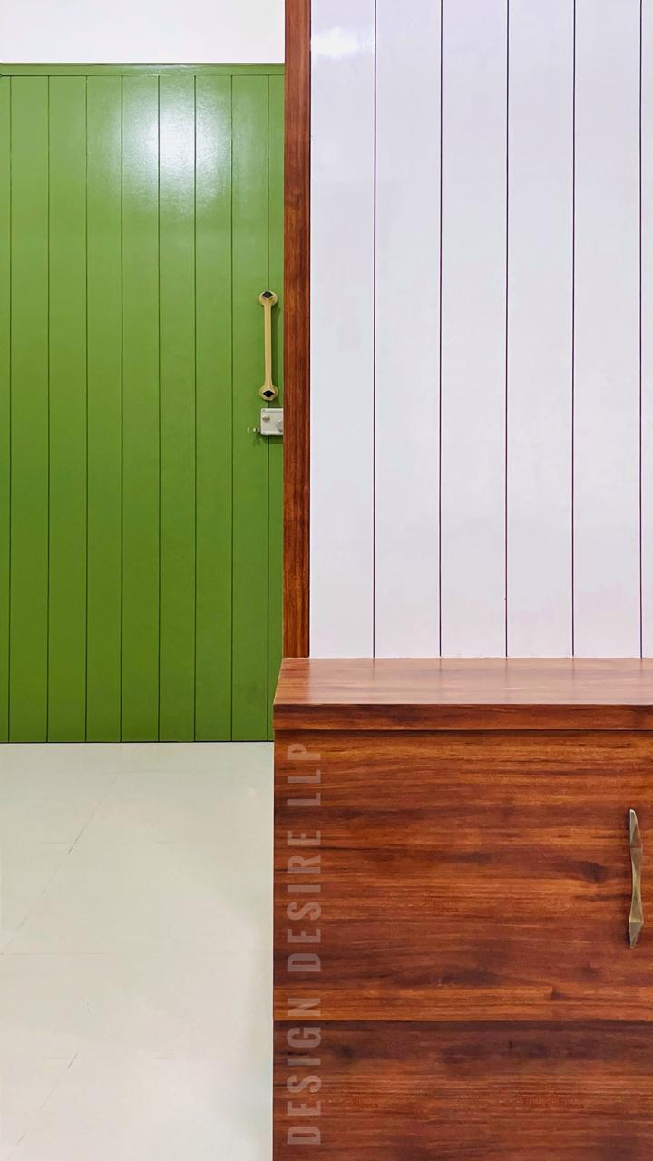 Foyer — grass-green door against a walnut trim & white panelling