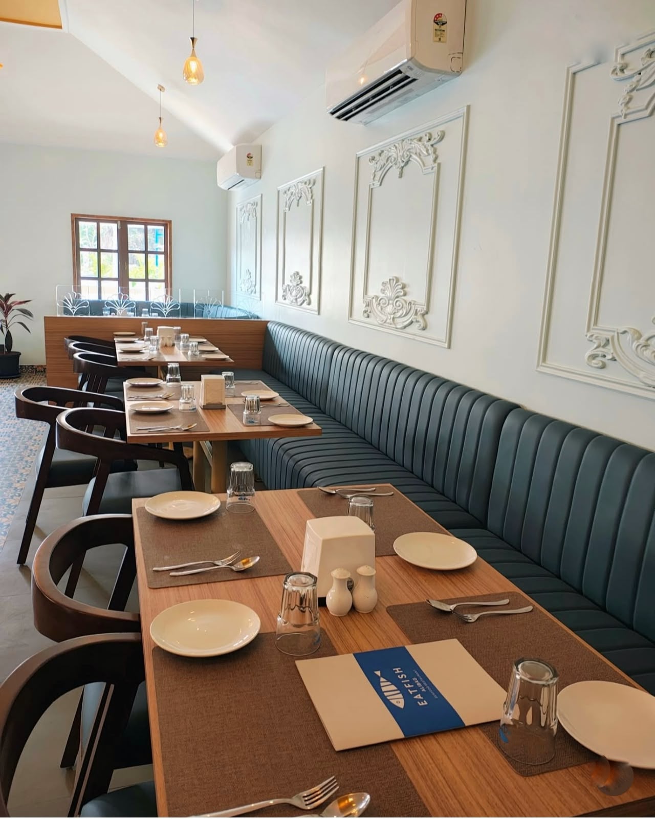 Indoor lounge — teal banquette & ornate French wall panels