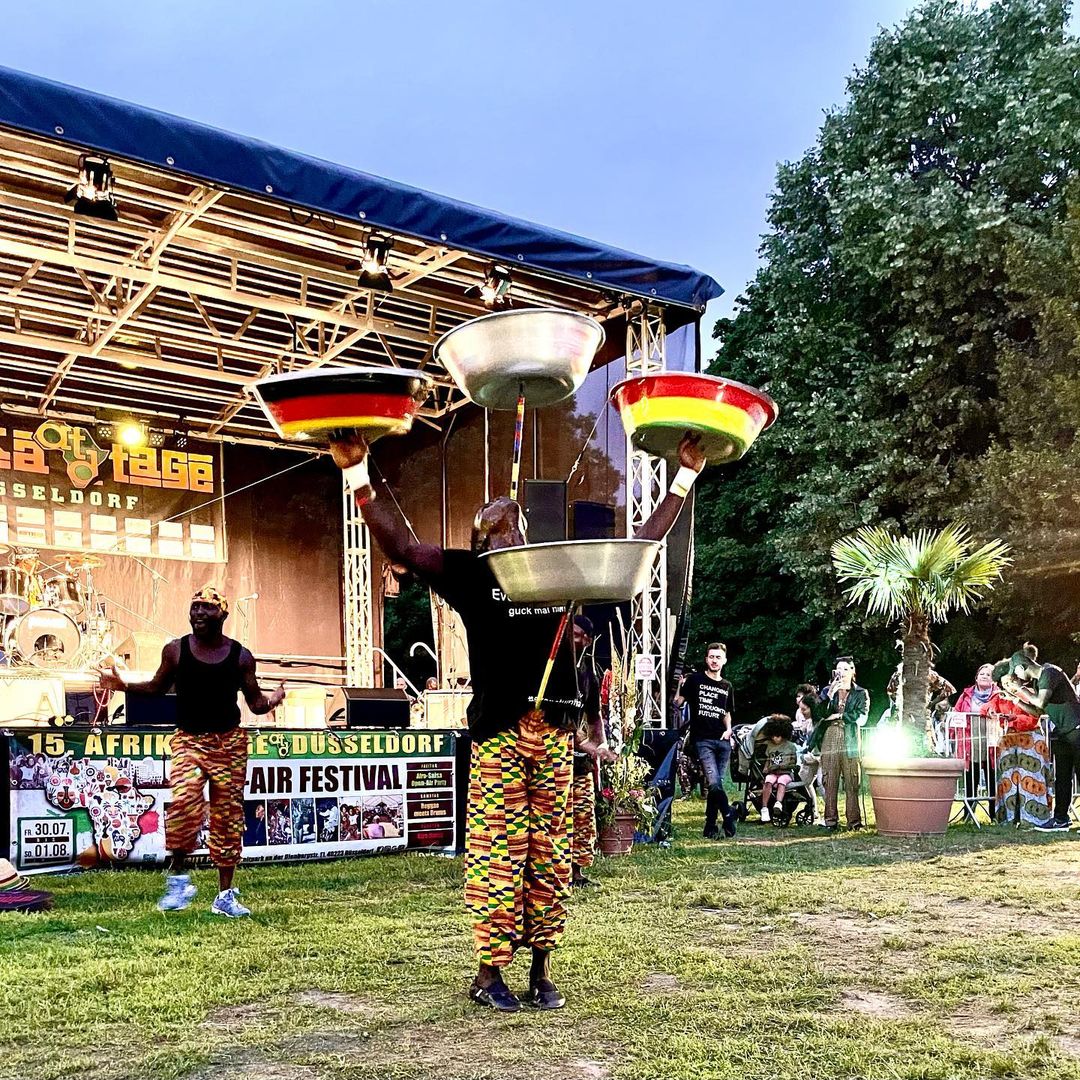 Akrobatische Performance bei den Afrikatagen — Künstler balancieren Schalen mit Deutschland- und Ghana-Flaggen